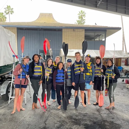 students posing for a group photo before kayaking